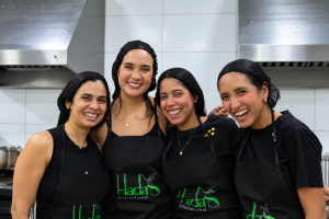 Equipo de cocina sonriente entre acero inoxidable